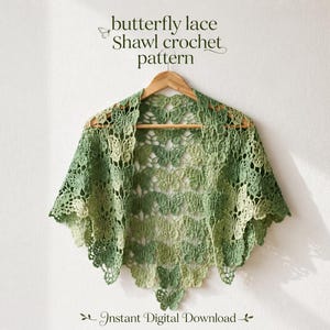 Puede incluir: Un chal de ganchillo verde con un patrón de encaje de mariposas repetido, colgado en una percha de madera. El texto superior dice butterfly lace Shawl crochet pattern y el texto inferior dice Instant Digital Download.