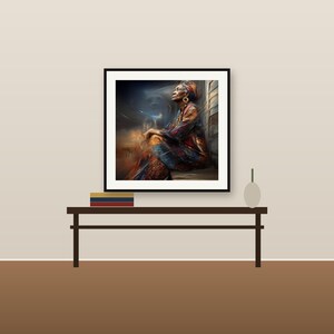 May include: A framed wall art print featuring a painting of a person with a head wrap, wearing patterned clothing in shades of orange, blue, and brown, sitting in a dimly lit space with swirling abstract light effects in the background.