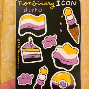 Pode incluir: Uma folha de autocolantes preta com o texto Nonbinary ICON: ditto e @saturdaaaaaaay. Inclui ilustrações da personagem Ditto em várias formas, incluindo uma bandeira, gelado, bolo, dango e uma bola, tudo em amarelo, branco, roxo e preto.