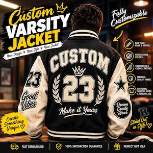May include: A black varsity jacket with white sleeves, featuring the text CUSTOM and the number 23 on the back. The jacket includes a crown graphic, laurel leaves, and the text Make it Yours. The sleeves display the number 23, Good Vibes, a star, and Dream Create Wear.