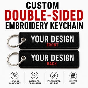 May include: Two rectangular black embroidered keychains with silver metal rings. The top keychain features white text reading YOUR DESIGN and red text reading FRONT. The bottom keychain features white text reading YOUR DESIGN and red text reading BACK.