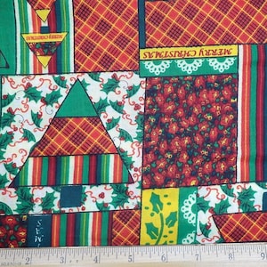 May include: A colorful fabric with a patchwork design featuring Christmas trees, holly, and the words "Merry Christmas". The fabric is red, green, white, and yellow.