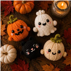 Może przedstawiać: Kolekcja szydełkowych figurek na Halloween, w tym pomarańczowa dynia z zieloną łodygą, biały duszek, czarny kot i kremowa dynia z zieloną łodygą, wszystkie z czarnymi bezpiecznymi oczkami i małymi różowymi policzkami z guzików.
