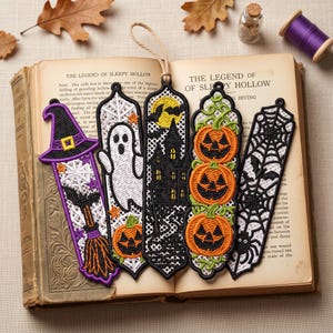 Op de afbeelding: Vijf verticale geborduurde boekenleggers met Halloween-motieven: een heksenhoed met bezem, een wit spook met pompoen, een zwart spookhuis met gele maan, drie gestapelde oranje pompoenen en een zwarte spin in een web.