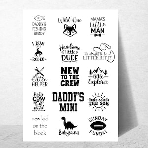 Op de afbeelding: Een wit vel met vijftien zwarte grafische ontwerpen met tekst, waaronder Daddy's Fishing Buddy, Wild One, Mama's Little Man, I Run This Rodeo, Handsome Little Dude, It's Alright To Be Little Bitty, Little Helper, New To The Crew, Little Explorer, Holy Cow I'm Cute, Daddy's Mini, Here Comes The Son, New Kid On The Block, Babysaurus en Sunday Funday.