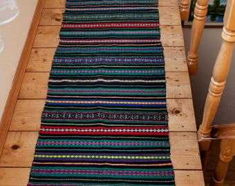 Camino de mesa vintage tejido a mano. Kilim a rayas de colores con detalles de lúrex, camino de mesa étnico rural. Decoración rústica antigua.