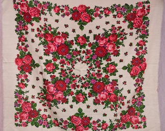 May include: A cream-colored square scarf with a vibrant floral pattern. The design features clusters of red and pink roses with green leaves, set against a neutral background. The scarf's edges are finished with a simple hem.