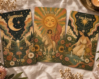 Può includere: Tre carte dei tarocchi rettangolari raffiguranti La Luna, Il Sole e La Stella. La carta della Luna mostra una luna crescente, lupi e fiori. La carta del Sole raffigura un volto solare, un bambino su un cavallo e girasoli. La carta della Stella mostra.