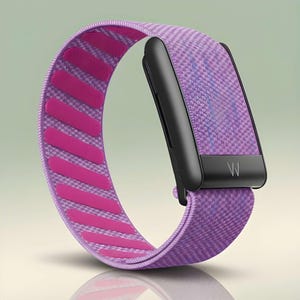 May include: A fitness tracker featuring a black rectangular display module with a white W logo at the bottom. The device includes a textured purple fabric strap with a series of bright pink horizontal silicone grip strips on the inner surface.