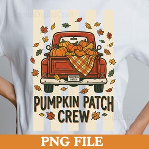May include: A white t-shirt featuring a graphic of a red pickup truck filled with orange pumpkins and a plaid blanket. The truck has a license plate that reads PUMPKIN PATCH. Below the truck, the text reads PUMPKIN PATCH CREW, surrounded by falling autumn leaves.