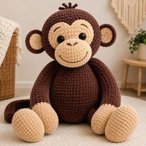 May include: A plush monkey toy crafted from dark brown and beige yarn. The monkey features a round head with large black eyes, a stitched smile, and prominent ears. Its body is round with beige hands and feet, and a long tail is visible.