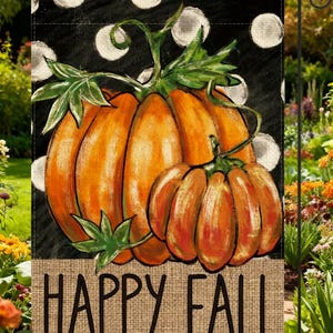 May include: A rectangular garden flag featuring two orange pumpkins with green stems and leaves against a black background with white polka dots. A tan burlap-textured horizontal band at the bottom displays the black text HAPPY FALL.