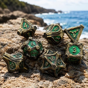May include: A set of seven polyhedral dice featuring an antique gold metal finish with intricate, raised branch-like detailing and vibrant green enamel inlays. Each die displays clear, embossed numbers, including a twenty-sided die and a percentile die.