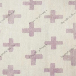 Könnte beinhalten: Ein Textilstoff mit einem sich wiederholenden Muster aus hellvioletten Pluszeichen auf cremefarbenem Hintergrund. Der Text RoyalRugDesign ist in einem sich wiederholenden diagonalen Muster in Hellgrau auf die Stoffoberfläche gedruckt.