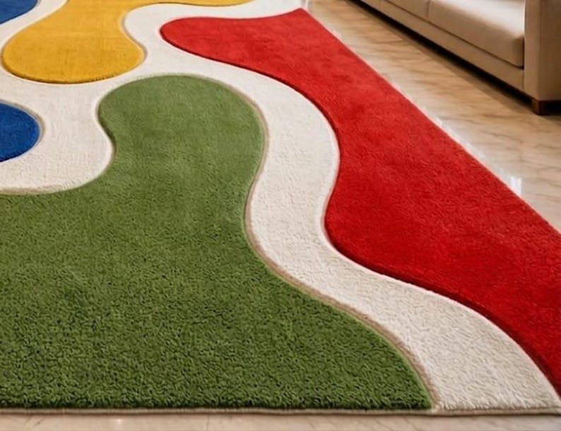 Peut inclure: Un tapis moelleux pr&eacute;sentant un motif abstrait audacieux compos&eacute; de grandes formes organiques ondul&eacute;es en rouge vif, vert olive, jaune &eacute;clatant et bleu profond, s&eacute;par&eacute;es par d'&eacute;paisses bordures blanches textur&eacute;es cr&eacute;ant un effet superpos&eacute;.