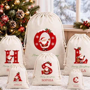 Pode incluir: Um conjunto de seis sacos de presente em tom creme com cordão em vários tamanhos, cada um com uma letra vermelha grande com efeito de neve, uma ilustração do Pai Natal e o texto Merry Christmas com um nome personalizado abaixo.