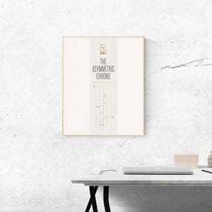 May include: A square framed wall art print featuring a white background with a central vertical panel. The panel displays a gold hourglass icon, the text THE ASYMMETRIC CHRONO in black, and a series of thin black vertical lines with small text labels.
