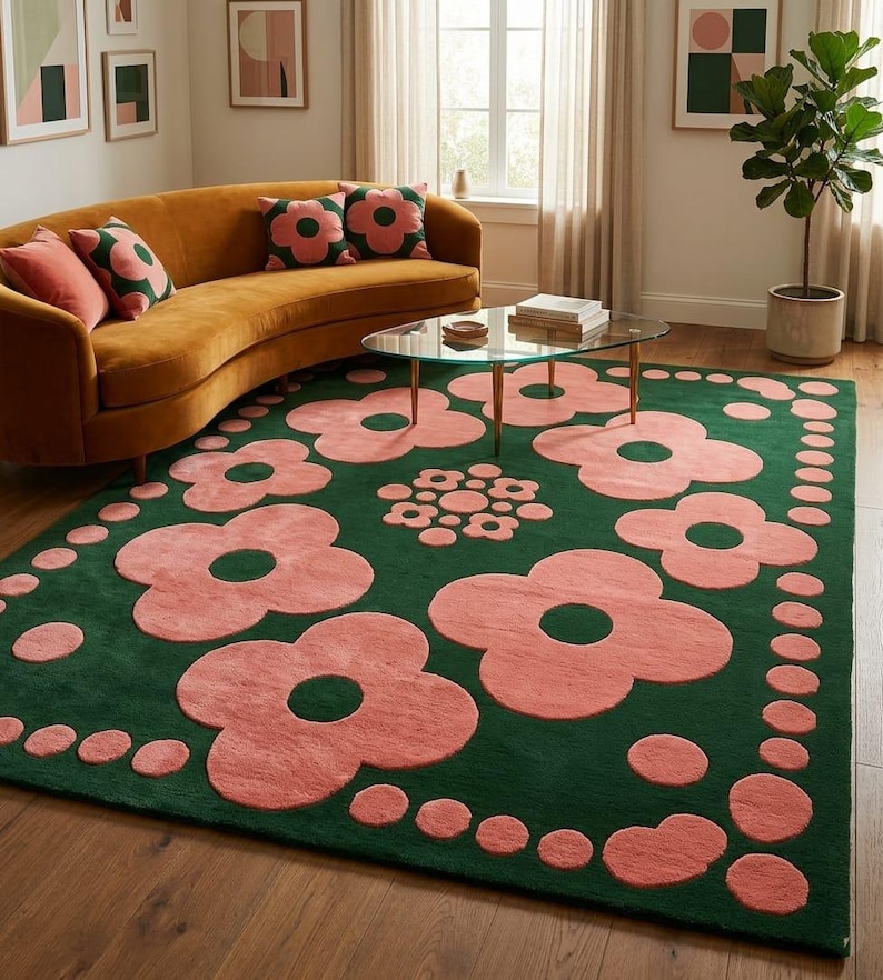 May include: A rectangular area rug featuring a deep forest green background with a repeating pattern of large, soft pink stylised flowers and smaller pink circular dots arranged in a border and a central cluster on the surface of the rug.