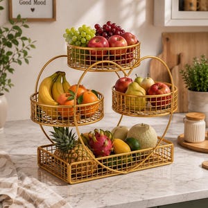 May include: A gold-colored metal tiered fruit stand featuring a rectangular base basket, two circular side baskets, and one top circular basket. The structure is accented with heart-shaped wire frames and is filled with various fresh fruits.