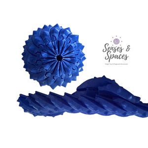 May include: A blue, articulated, spherical fidget toy with a textured, geometric surface and a central hole, accompanied by a matching blue, elongated, segmented, flexible piece. The text Senses & Spaces Fidget Toys & Pegboard Accessories is visible.