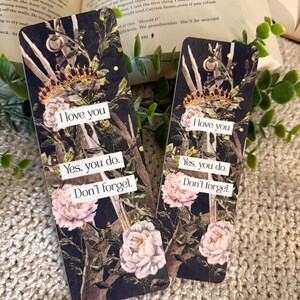 May include: Two rectangular bookmarks featuring a dark botanical background with pink peonies, green foliage, and a gold crown. Each bookmark displays the white text: I love you, Yes, you do, Don't forget, printed on three separate white rectangular labels.