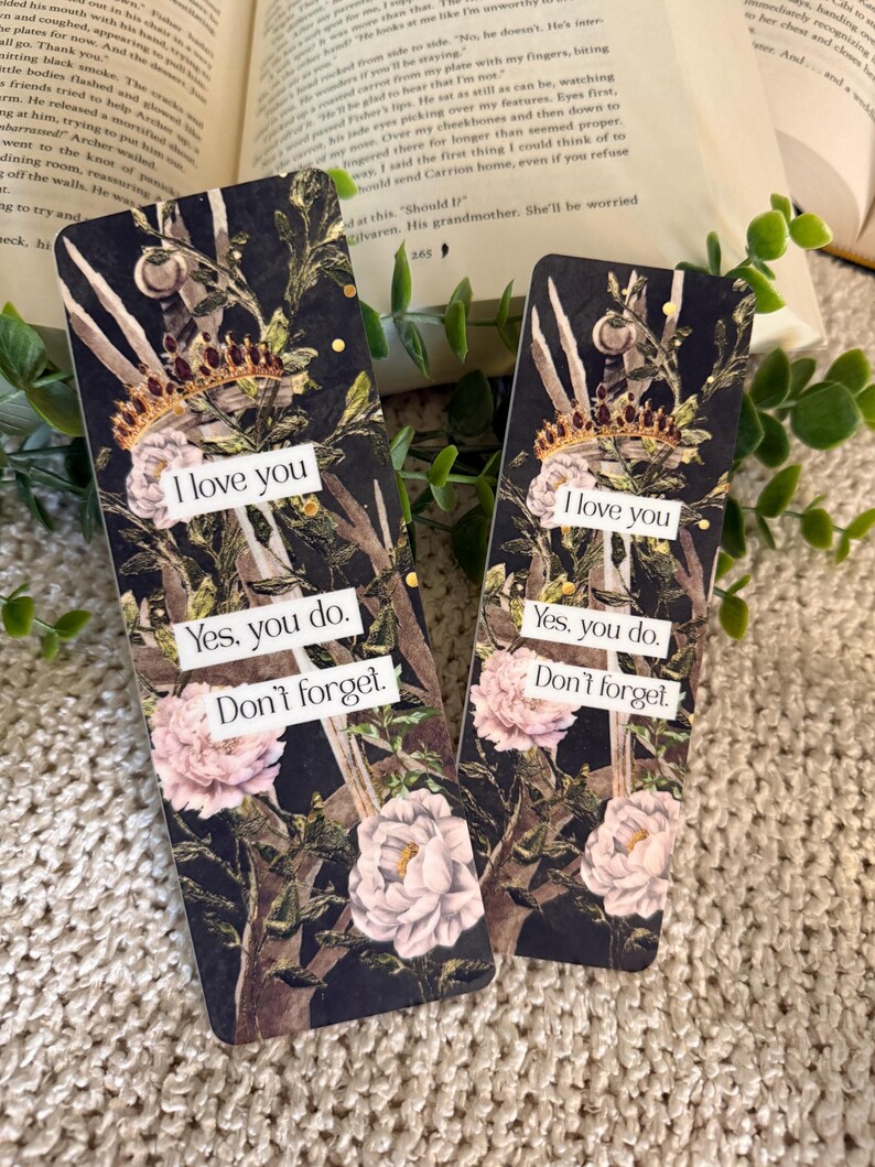 May include: Two rectangular bookmarks featuring a dark botanical background with pink peonies, green foliage, and a gold crown. Each bookmark displays the white text: I love you, Yes, you do, Don't forget, printed on three separate white rectangular labels.
