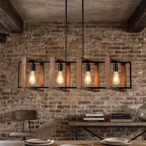 Peut inclure: Un lustre linéaire rectangulaire doté de quatre ampoules encastrées dans des cadres en bois individuels avec des accents en métal noir. Le luminaire est suspendu par deux fines tiges noires et émet une lueur chaude, alliant bois naturel et métal sombre.