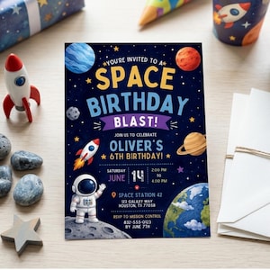 May include: A rectangular space-themed birthday invitation card with a dark blue background featuring planets, stars, a rocket, and an astronaut. The text reads: YOU'RE INVITED TO A SPACE BIRTHDAY BLAST! JOIN US TO CELEBRATE OLIVER'S 6TH BIRTHDAY!