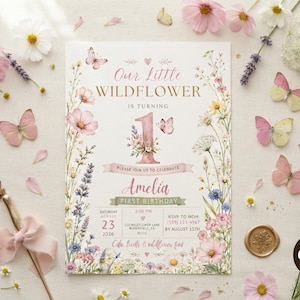 以下が含まれることがあります： 花柄の縁取り、ピンクと黄色の蝶、Our Little Wildflower is turning 1、Ameliaという文字、イベント詳細が記載された1歳の誕生日招待状。明るい背景にピンクの花とラベンダーの小枝が散りばめられています。