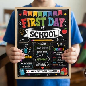 May include: A rectangular chalkboard sign with a light wood frame featuring colourful text and graphics. It reads FIRST DAY OF SCHOOL, JULY 22, 2026, 1ST GRADE, 6 YEARS OLD, MS. SMITH, ASTRONAUT, PIZZA, BLUE, DOG MAN, SOCCER, and I AM SO EXCITED FOR THIS YEAR.