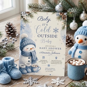 May include: A rectangular baby shower invitation card featuring a snowman illustration, blue knitted baby booties, and text reading Baby, It's Cold Outside Baby, Join Us For A Baby Shower Honoring Amanda Johnson, Saturday January 18, 2026, 2:00 PM.