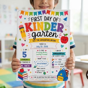 May include: A white rectangular sign titled First Day of Kindergarten with colorful illustrations of a pencil, apple, and backpack. The text includes July 22, 2026, age 5, teacher Ms. Smith, interests like drawing and pizza, and the goal to be an astronaut.