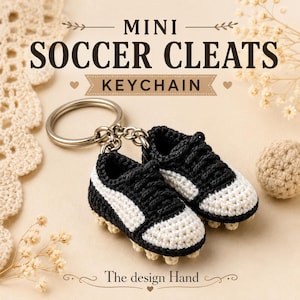May include: A pair of miniature crocheted football boots attached to a silver metal keyring. The shoes are black with white toe caps and white side stripes, featuring small crocheted studs on the soles. Text reads MINI SOCCER CLEATS KEYCHAIN.