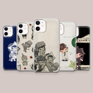 Op de afbeelding: Vijf smartphonehoesjes met Hirono-karakterillustraties. De ontwerpen omvatten een donkerblauw hoesje, een crèmekleurig hoesje met kleine karakterschetsen en rode sterren, een centraal crèmekleurig hoesje met een collage, een wit hoesje en een zwart hoesje.