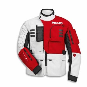 Può includere: Una giacca da moto bianca e rossa con il logo Ducati sul petto e sulla manica. La giacca presenta diverse tasche con cerniera, una tasca in rete nera sul petto, dettagli neri e un colletto alto con chiusura a zip frontale.
