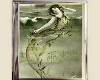 May include: A vintage illustration of a mermaid with green seaweed and a tail, surrounded by bubbles and small fish. The image is in a silver frame and has the text "The Mermaid" written in cursive.