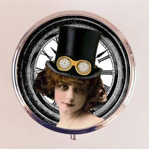 May include: A vintage-inspired compact mirror with a black and white clock face design. A woman wearing a black top hat with goggles and a white shirt is featured in the center of the mirror.