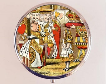 May include: A round, silver compact mirror with a colorful image of Alice in Wonderland characters. The image features Alice, the Queen of Hearts, and other characters from the story. The Queen of Hearts is holding a heart-shaped object and is wearing a red and white dress. Alice is wearing a blue and white dress and is standing in front of the Queen of Hearts.