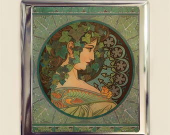 May include: A silver metal framed picture with a colorful art nouveau style image of a woman with green ivy in her hair. The woman is wearing a green and orange dress with a yellow flower.