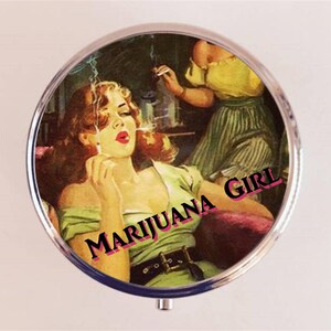 May include: A round, silver compact with a vintage image of a woman smoking a cigarette. The text "MARIJUANA GIRL" is printed in pink letters on the compact.