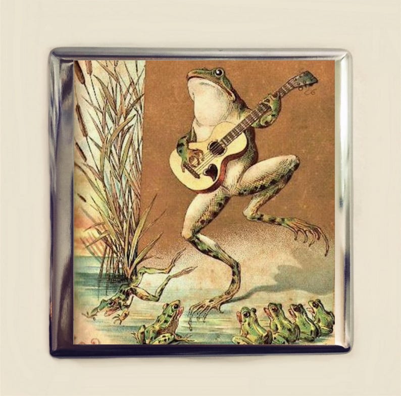 Puede incluir: Una rana verde tocando la guitarra con un grupo de ranas m&aacute;s peque&ntilde;as escuchando. La imagen es de estilo vintage con un fondo marr&oacute;n y juncos verdes.