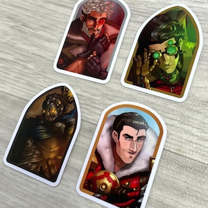 May include: Four die-cut stickers featuring illustrated characters in arched frames. One shows a man with a red eye, another a person with green goggles, a third a dark armored figure, and the fourth a man in a red coat with a fur collar.