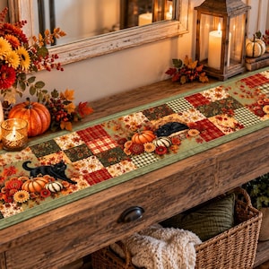 May include: A rectangular fabric table runner featuring a patchwork design of autumn-themed squares in shades of orange, red, green, and brown. The pattern includes illustrations of black cats, orange pumpkins, white gourds, and various fall flowers.