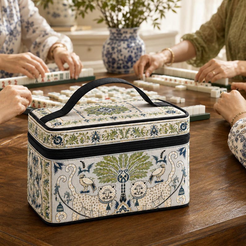 May include: A rectangular fabric vanity case featuring a cream background with a repeating pattern of green palm trees, two spotted leopards, and small birds. The case has a black zipper closure, a top handle, and blue and green floral borders.