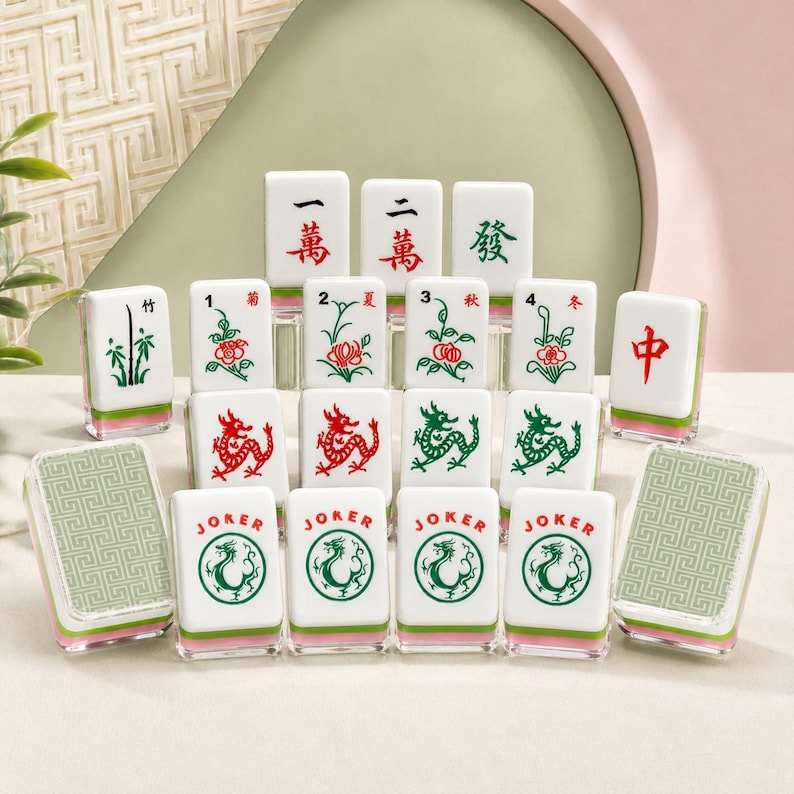 May include: A collection of white Mahjong tiles featuring various red and green engraved symbols, including Chinese characters, floral patterns, dragons, and Joker tiles with circular dragon motifs, all with a green geometric pattern on the back.