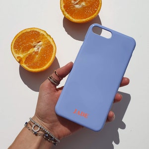 May include: A lavender phone case with the name "JADE" printed in orange on the back.