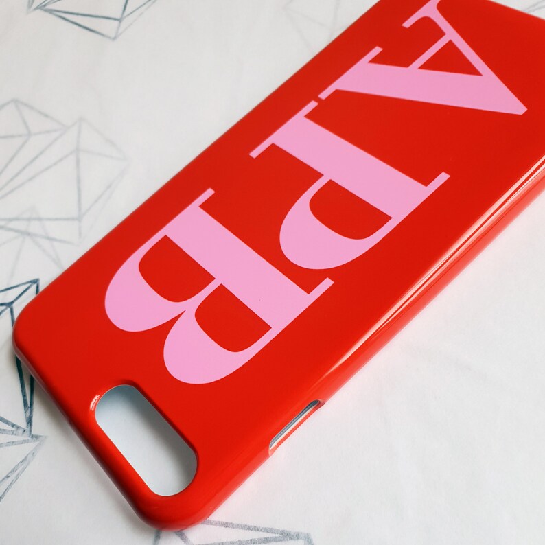 May include: A red phone case with the letters "ABP" in pink.