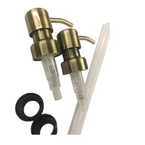 May include: Two gold soap pumps with clear tubes and black rubber rings. The pumps have a lever on the side to dispense soap.