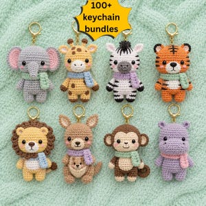 May include: A collection of eight crocheted animal keychains featuring an elephant, giraffe, zebra, tiger, lion, kangaroo with joey, monkey, and hippo, each wearing a small scarf, with the text 100+ keychain bundles displayed at the top.