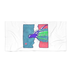May include: A white rectangular beach towel featuring a central graphic illustration of a purple lizard perched on a green cactus. The background is split into a blue section with a small red circle and a pink section, all outlined in dark blue.